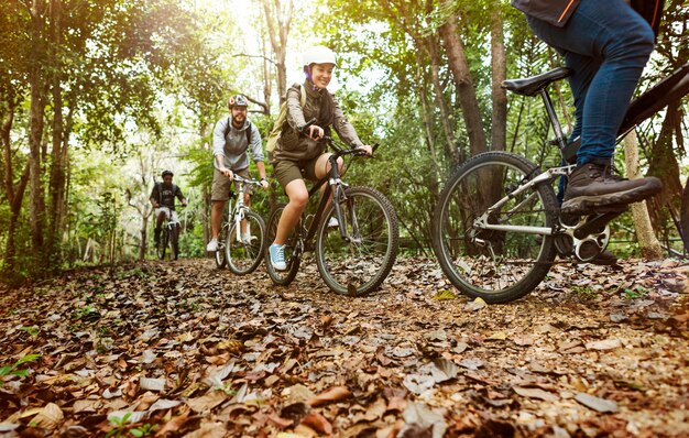 Grupo de amigos en bicicleta de montaña en el bosque juntos