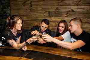 Foto gratuita grupo de amigos brindando vasos de bebidas en el bar