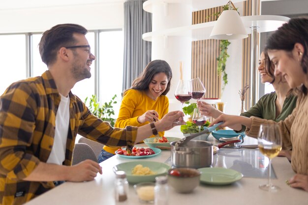 Grupo de amigos brindando con vino en la cocina