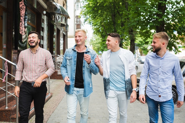 Foto gratuita grupo de amigos caminando en la calle de la ciudad