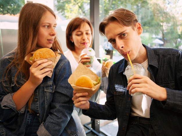 Grupo de amigos comiendo comida rápida