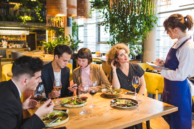 Grupo de amigos comiendo en restaurante