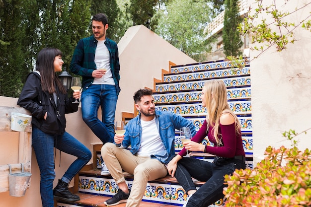 Grupo de amigos con copas de vino en la escalera