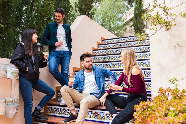 Grupo de amigos con copas de vino en la escalera