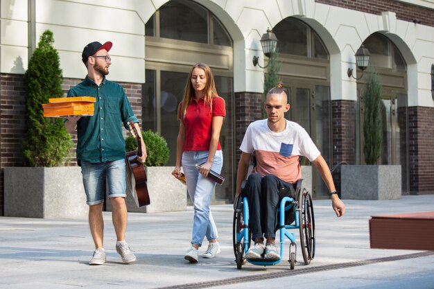 Grupo de amigos dando un paseo por las calles de la ciudad en verano