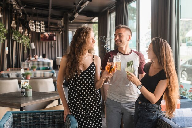 Grupo de amigos con diferentes tipos de bebidas alcohólicas en el restaurante