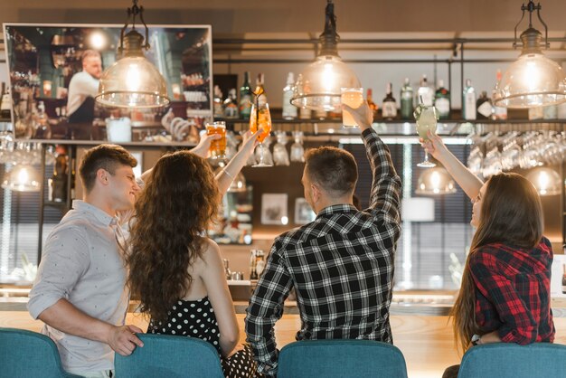 Grupo de amigos disfrutando de bebidas en el bar