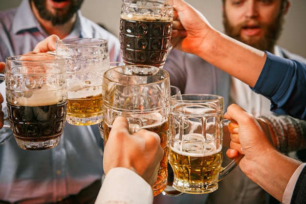 Foto gratuita grupo de amigos disfrutando de bebidas por la noche con cerveza