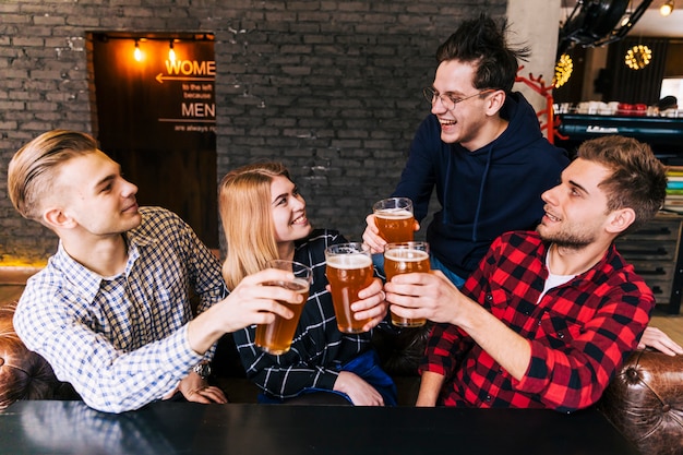 Grupo de amigos disfrutando de la cerveza en pub.