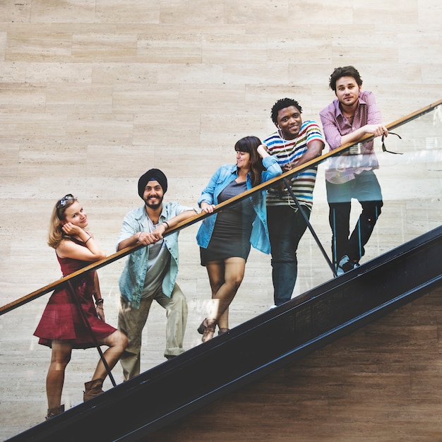 Foto gratuita grupo de amigos de la diversidad de pie en la escalera