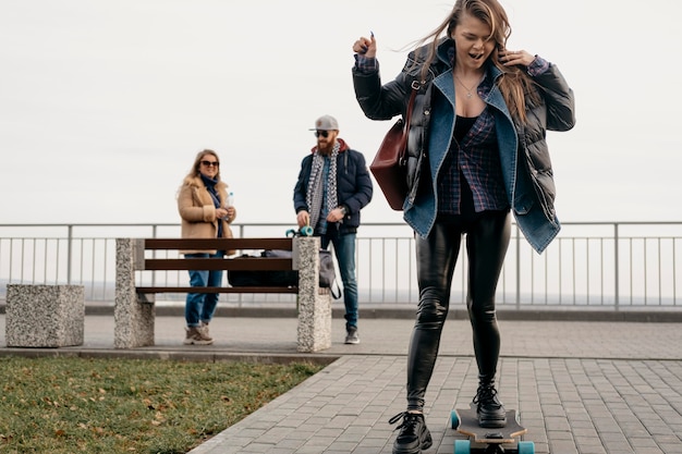 Grupo de amigos divirtiéndose al aire libre con patinetas