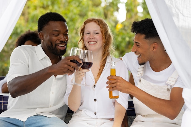 Grupo de amigos divirtiéndose durante una fiesta blanca con bebidas