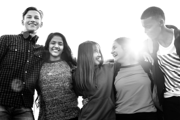 Grupo de amigos de la escuela al aire libre se arracima mutuamente unidad y concepto de comunidad