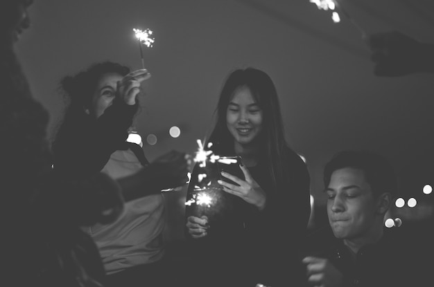 Grupo de amigos de la escuela felicidad y jugando fuegos artificiales