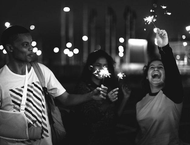 Grupo de amigos de la escuela felicidad y jugando fuegos artificiales