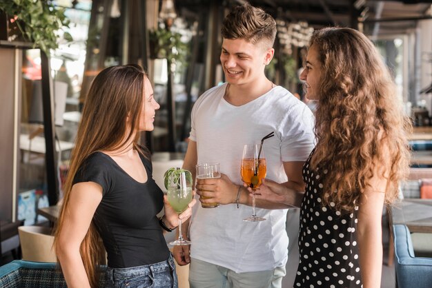 Grupo de amigos felices celebrando con bebidas en el restaurante