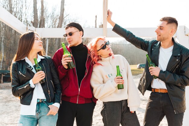 Grupo de amigos felices con cerveza divirtiéndose juntos