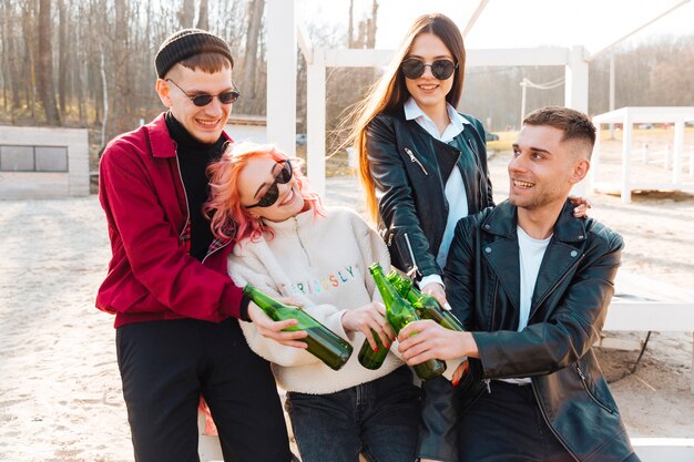 Grupo de amigos felices con cerveza riendo juntos