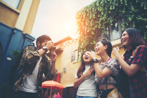 Grupo de amigos felices tomando selfies juntos en escena urbana