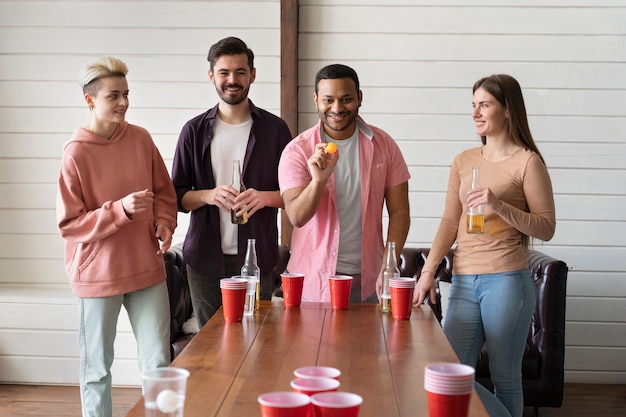 Foto gratuita grupo de amigos jugando al beer pong juntos en una fiesta