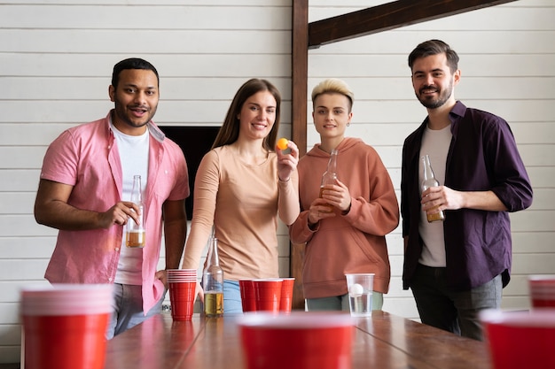 Grupo de amigos jugando al beer pong juntos en una fiesta