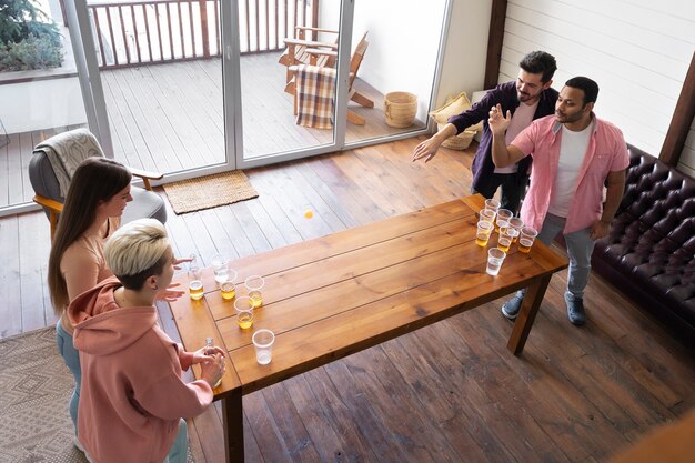 Grupo de amigos jugando al beer pong juntos en una fiesta