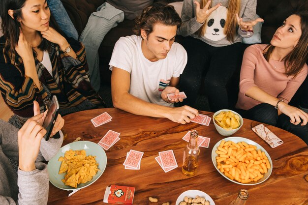 Grupo de amigos jugando a las cartas