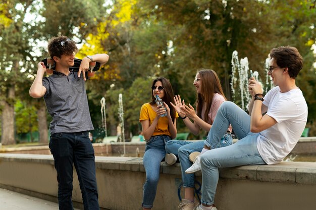 Grupo de amigos, pasar tiempo juntos al aire libre junto a la fuente