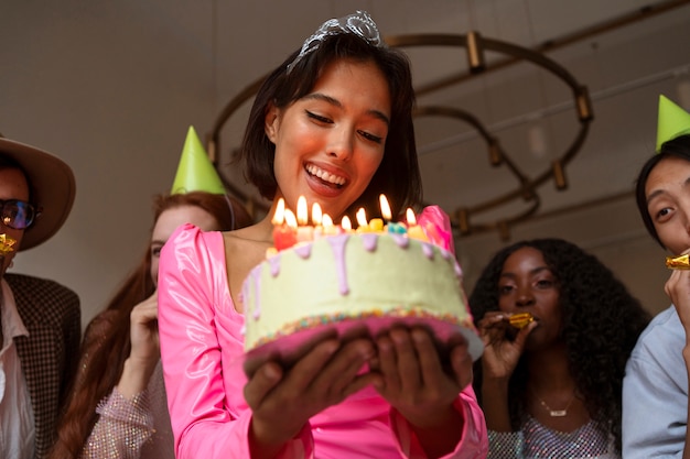 Grupo de amigos con pastel en una fiesta sorpresa de cumpleaños