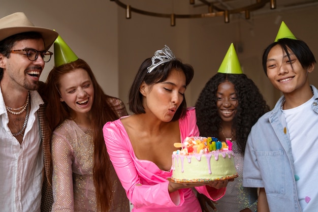 Grupo de amigos con pastel en una fiesta sorpresa de cumpleaños