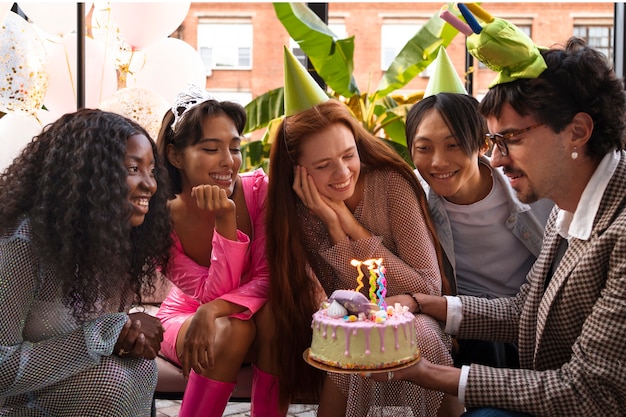 Grupo de amigos con pastel en una fiesta sorpresa de cumpleaños