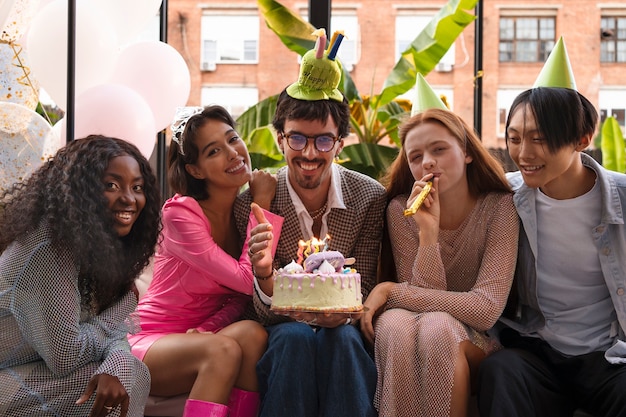 Grupo de amigos con pastel en una fiesta sorpresa de cumpleaños