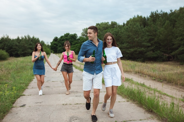 Grupo de amigos durante el picnic en el bosque de verano