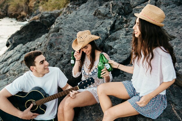 Grupo de amigos en la playa con guitara