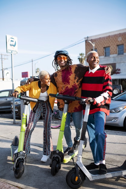 Grupo de amigos posando en scooters eléctricos afuera de la ciudad