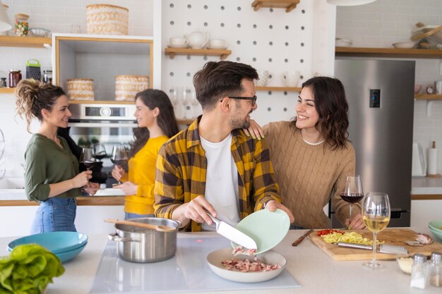 Grupo de amigos preparando comida en la cocina