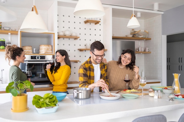 Grupo de amigos preparando comida en la cocina