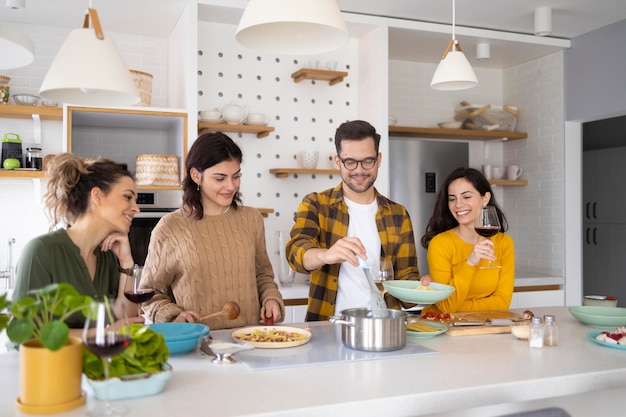 Grupo de amigos preparando comida en la cocina