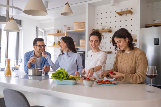 Grupo de amigos preparando comida en la cocina