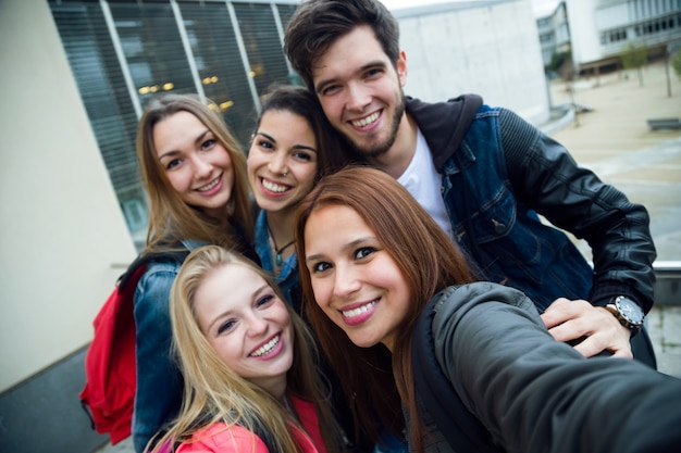 Grupo de amigos que se divierten en la calle después de la clase.