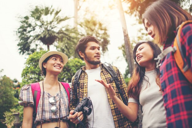 Grupo de amigos que se divierten hablando juntos mientras viajan en zonas urbanas.