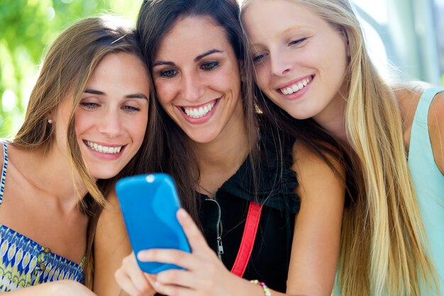 Grupo de amigos que se divierten con los smartphones.