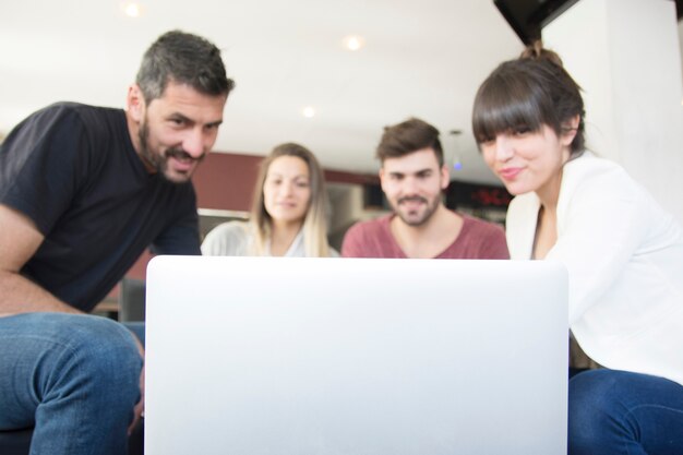 Grupo de amigos que miran la computadora portátil