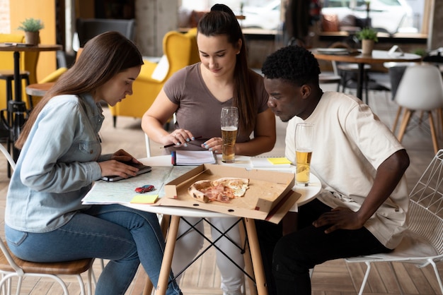 Grupo de amigos que planean un viaje en un café