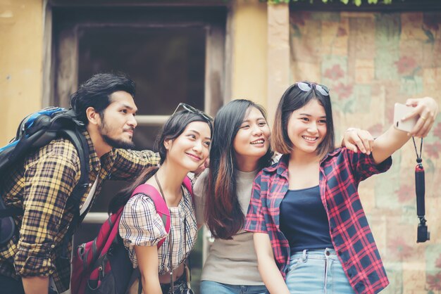 Grupo de amigos que toman selfie en una calle urbana que se divierten juntos.