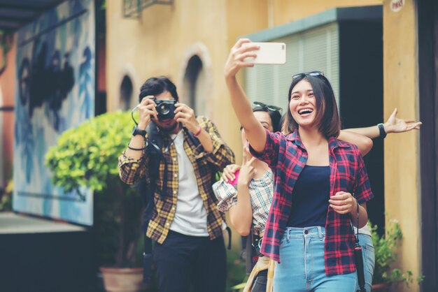 Grupo de amigos que toman selfie en una calle urbana que se divierten juntos.