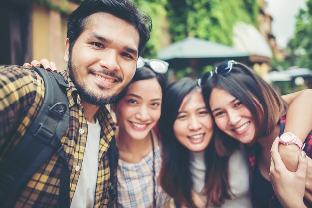 Grupo de amigos que toman selfie en una calle urbana que se divierten juntos.