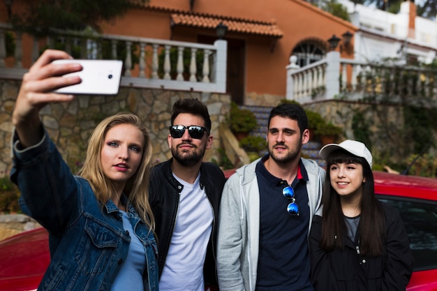 Grupo de amigos que toman selfie con teléfono móvil