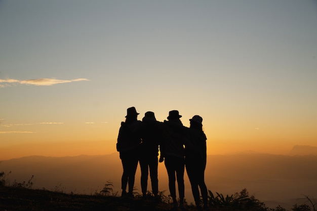 Grupo de amigos que se unen en greensward y que se gozan.