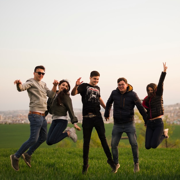 Grupo de amigos saltando en la naturaleza